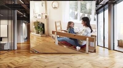 Daughter Sitting On Mother's Lap At Home And Laughing Wall mural