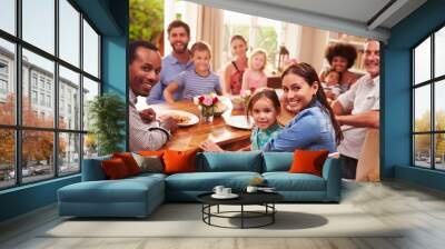 family and friends sitting at a dining table, looking at camera Wall mural