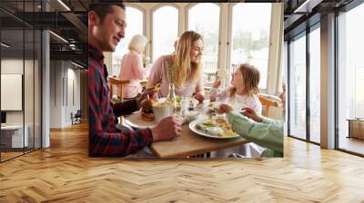 Family Enjoying Meal In Restaurant Together Wall mural