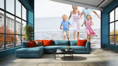 family running on beach smiling Wall mural