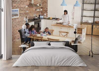 Father And Children Drawing At Table As Mother Prepares Meal Wall mural