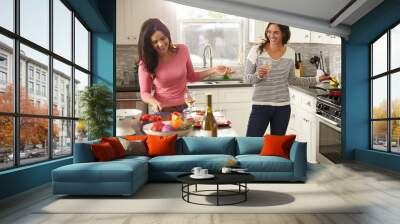 Female gay couple preparing meal together and drinking wine Wall mural