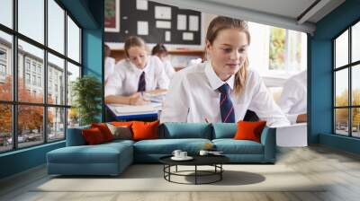 Female Pupil Wearing Uniform Using Laptop In Classroom Wall mural