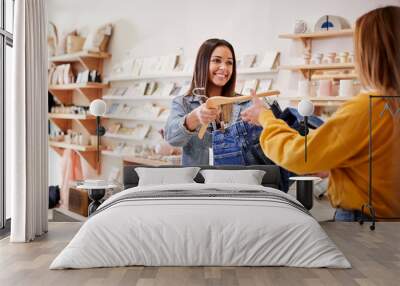 Female Sales Assistant In Independent Clothing And Gift Store Serving Female Customer Wall mural