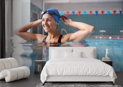 Female Swimmer Wearing Hat And Goggles Training In Swimming Pool Wall mural