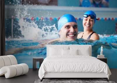 Female Swimming Teacher Giving Man One To One Lesson In Pool Wall mural