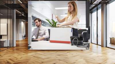 Fired female employee packing box of belongings in an office Wall mural