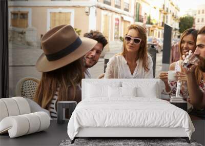 Friends on vacation sit talking outside a cafe in Ibiza Wall mural