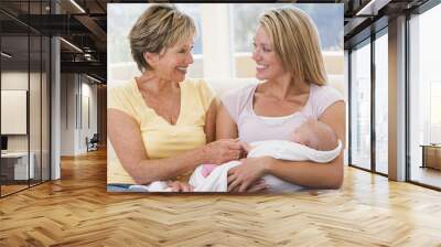 Grandmother and mother in living room with baby smiling Wall mural