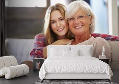 grandmother with adult granddaughter relaxing on sofa Wall mural