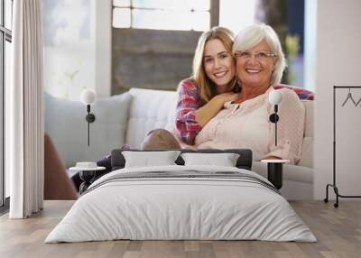 grandmother with adult granddaughter relaxing on sofa Wall mural