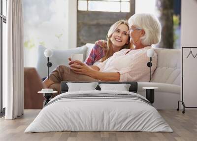 Grandmother With Adult Granddaughter Relaxing On Sofa Wall mural