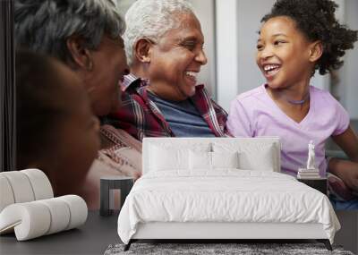 Grandparents Relaxing On Sofa At Home With Granddaughters Wall mural