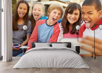 Group Of Children Sitting On Bench In Mall Taking Selfie Wall mural