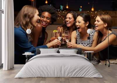 Group Of Female Friends Enjoying Night Out At Rooftop Bar Wall mural