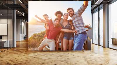 Group Of Friends Standing By Car On Coastal Road At Sunset Wall mural