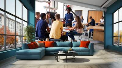 Group Of High School Students Sitting At Work Benches Listening To Teacher In Design And Technology Lesson Wall mural