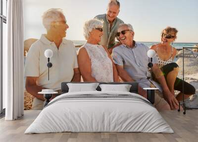 Group Of Senior Friends Sitting On Rocks By Sea On Summer Group Vacation Wall mural