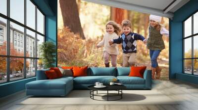 Group Of Young Children Running Along Path In Autumn Forest Wall mural