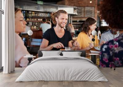 Group Of Young Friends Meeting For Drinks And Food In Restaurant Wall mural