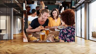 Group Of Young Friends Meeting For Drinks And Food In Restaurant Wall mural