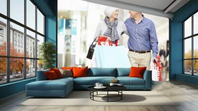 Happy Senior Couple Carrying Bags In Shopping Mall Wall mural