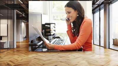 Hispanic woman working in home office Wall mural