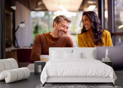 Male And Female Business Colleagues Meeting Around Laptop In Modern Office Wall mural