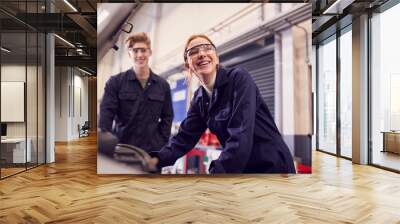 Male And Female Students Looking At Car Engine On Auto Mechanic Apprenticeship Course At College Wall mural