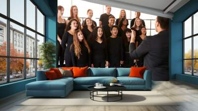 Male And Female Students Singing In Choir With Teacher At Performing Arts School Wall mural