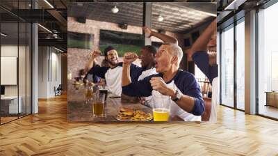 Male Friends In Sports Bar Watch Game And Celebrate Wall mural