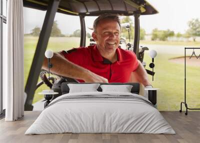 Mature Man Playing Golf Driving Buggy Along Course To Green On Red Letter Day Wall mural