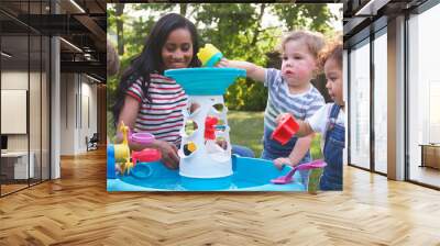 Mother And Young Children Playing With Water Table In Garden Wall mural