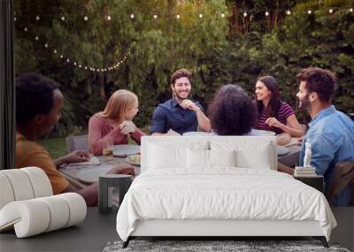 Multi-Cultural Friends At Home Sitting At Table Enjoying Food At Summer Garden Party Wall mural