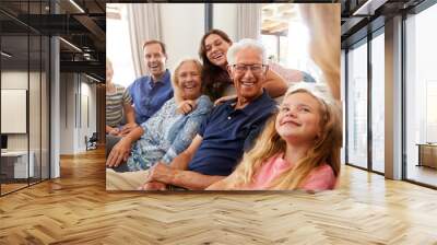 Multi-Generation Family Sitting On Sofa At Home Relaxing And Chatting Wall mural