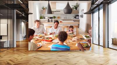 Multi-Generation Mixed Race Family Eating Meal Around Table At Home Together Wall mural