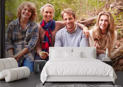 Parents and teenage kids eating outdoors in a forest, portrait Wall mural