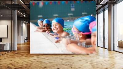 portrait of children in water at edge of pool waiting for swimming lesson Wall mural