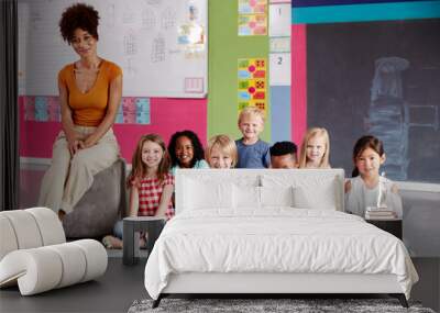 Portrait Of Elementary School Pupils Sitting On Floor In Classroom With Female Teacher Wall mural