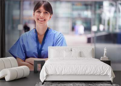 Portrait Of Female Doctor Wearing Scrubs Standing In Modern Hospital Building Wall mural