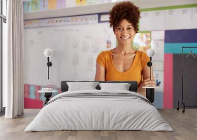 Portrait Of Female Elementary School Teacher Standing In Classroom Wall mural