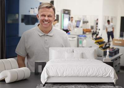 Portrait Of Male Engineer On Factory Floor Of Busy Workshop Wall mural