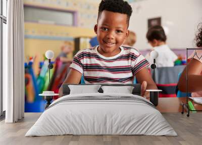 Portrait Of Male Pupil In Elementary School Drawing Using Digital Tablet In Classroom Wall mural