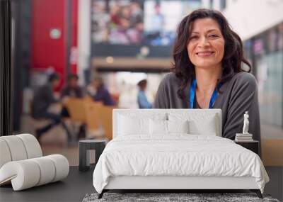 Portrait Of Mature Female Teacher Or Student With Digital Tablet Working At Table In College Hall Wall mural