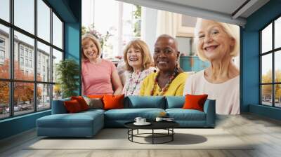 Portrait Of Senior Female Friends Relaxing On Sofa At Home Wall mural