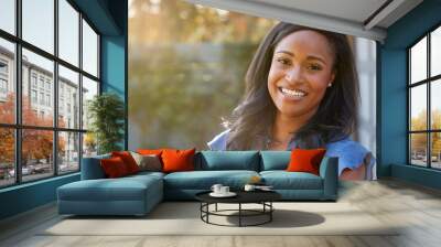 Portrait Of Smiling African American Woman In Garden At Home Against Flaring Sun Wall mural