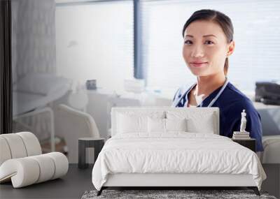 Portrait Of Smiling Female Doctor With Stethoscope Standing By Desk In Office Wall mural