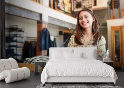 Portrait Of Smiling Female Owner Of Fashion Store Standing In Front Of Clothing Display Wall mural