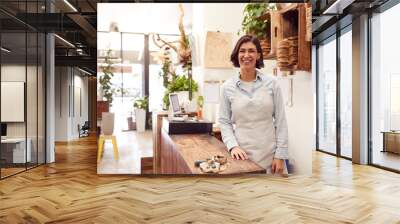 Portrait Of Smiling Female Sales Assistant Standing Behind Sales Desk Of Florists Store Wall mural