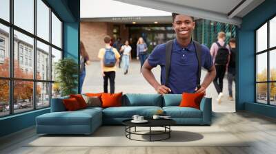 Portrait Of Smiling Male High School Student Outside College Building With Other Teenage Students In Background Wall mural